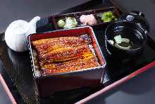 Super Deluxe eel served over rice in a lacquered boxThe size of the eel is three-quarters of a tail.The size of the eel is three-quarters of a tail